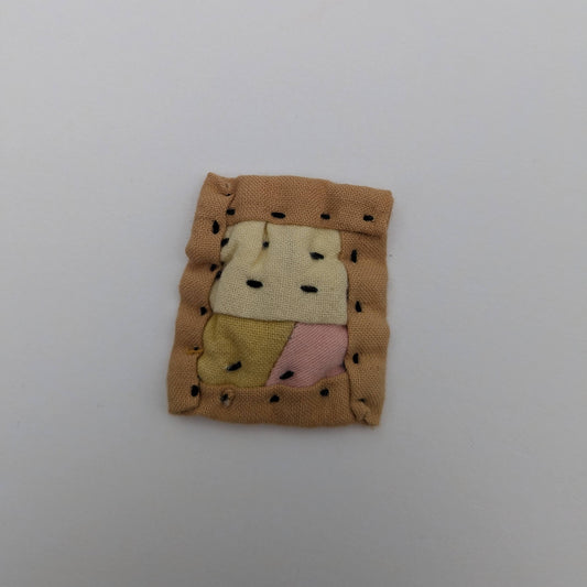 Square patchwork magnet in brown, yellow, and pink