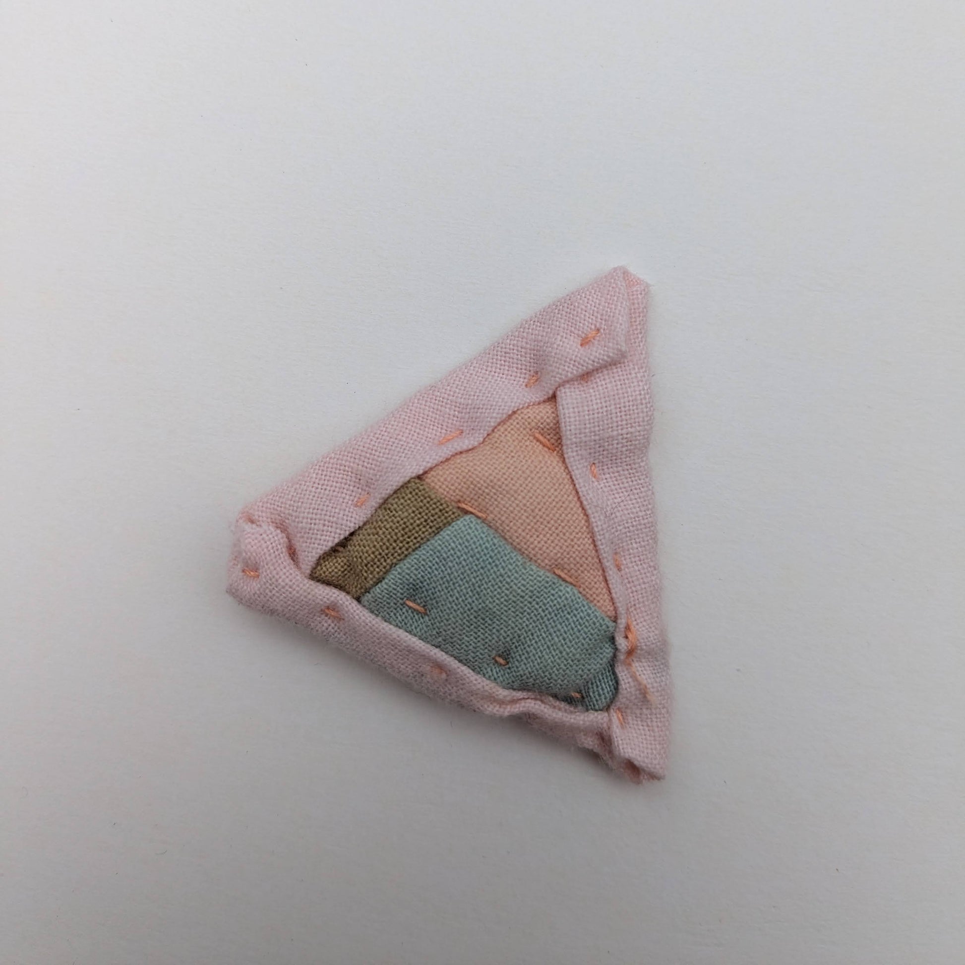 Triangular quilted magnet blue, green, and pink.