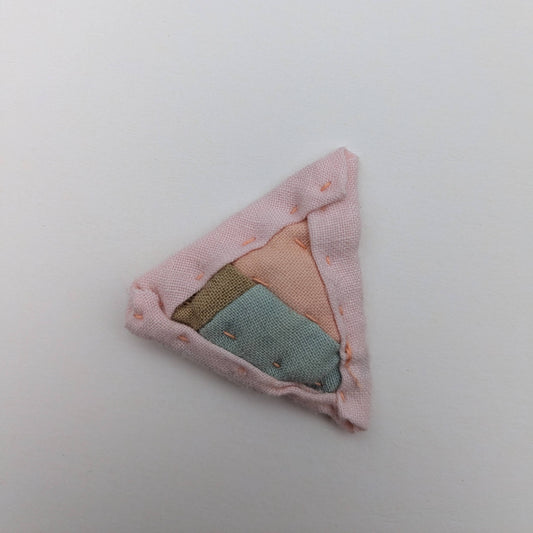 Triangular quilted magnet blue, green, and pink.
