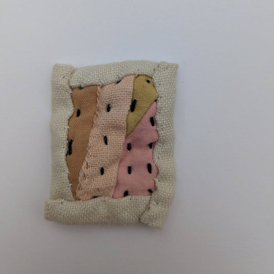 Rectangle patchwork magnet in pink, orange, andyellow.