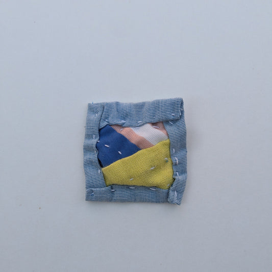 Square patchwork magnet with blue, pink, and bright green